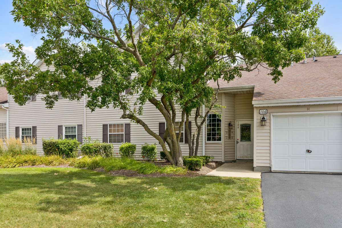 106 Gant Circle, Unit H Streamwood, IL 60107 - Photo 1 of 20 a front view of a house with a yard garage and outdoor seating