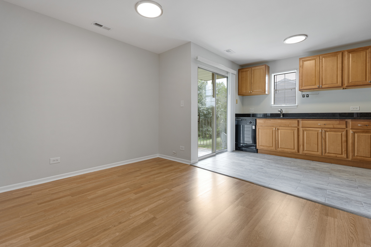 106 Gant Circle, Unit H Streamwood, IL 60107 - Photo 5 of 20 a view of a kitchen with a sink and dishwasher with wooden floor