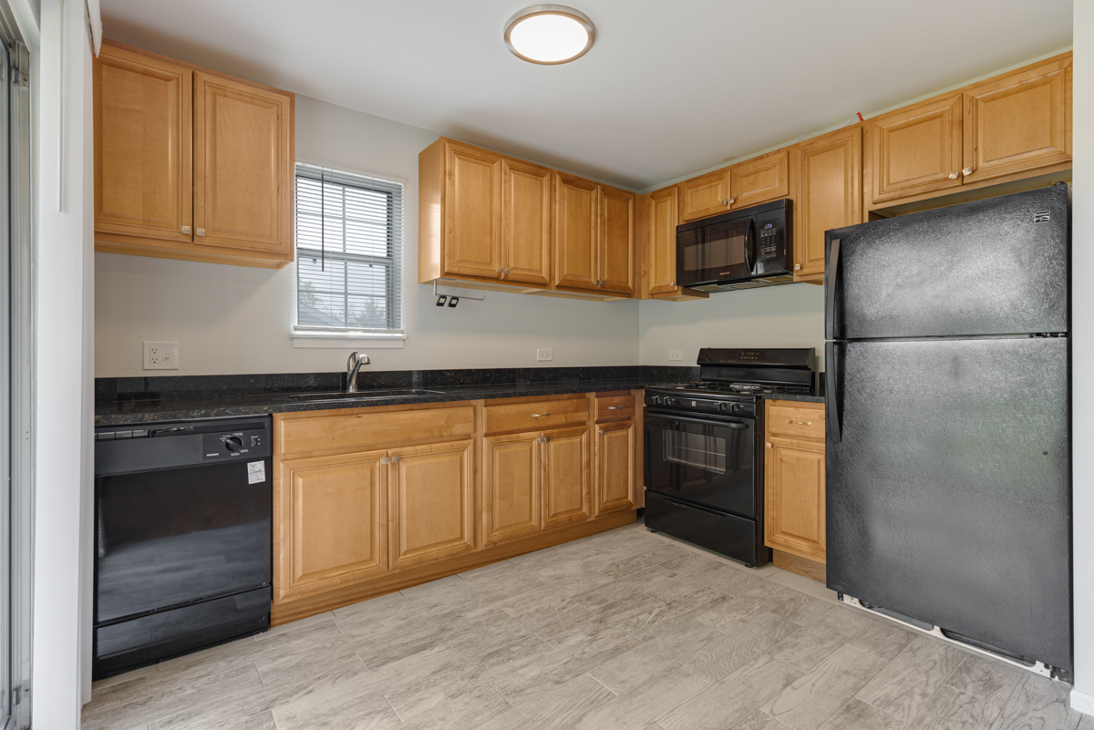 106 Gant Circle, Unit H Streamwood, IL 60107 - Photo 6 of 20 a kitchen with stainless steel appliances granite countertop a stove a sink and a refrigerator