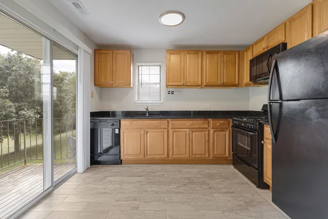 a kitchen with granite countertop a refrigerator and a sink