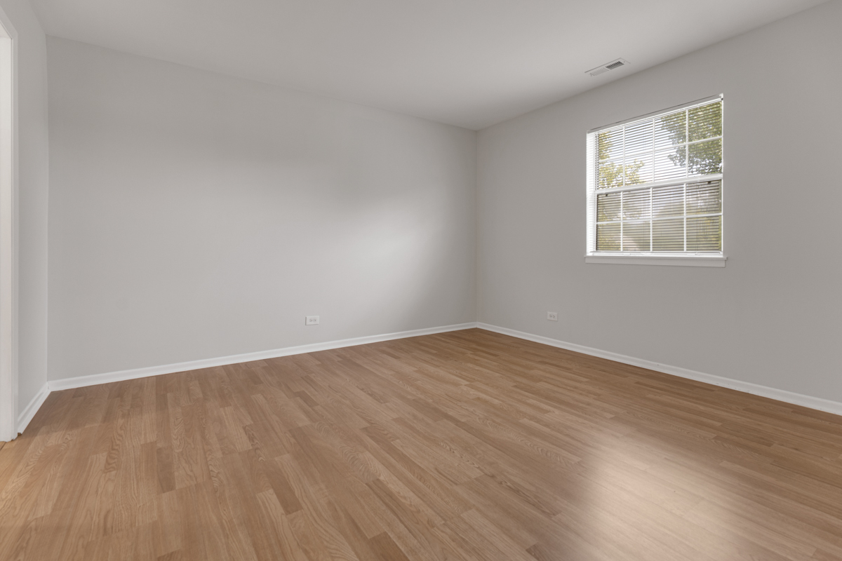 106 Gant Circle, Unit H Streamwood, IL 60107 - Photo 10 of 20 wooden floor in an empty room with a window
