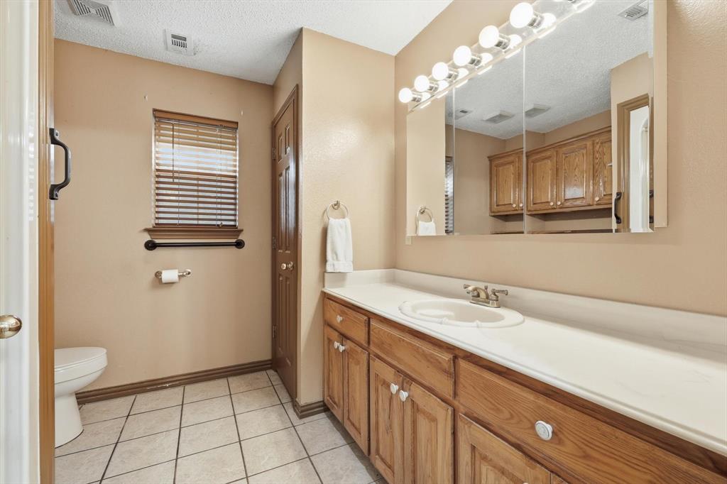 135 Private Road 2202 Decatur, TX 76234 - Photo 16 of 40 Full bath featuring vanity, a closet, a textured ceiling, and light tile patterned flooring