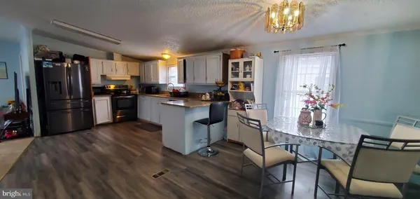 a kitchen with a sink a stove cabinets and wooden floor
