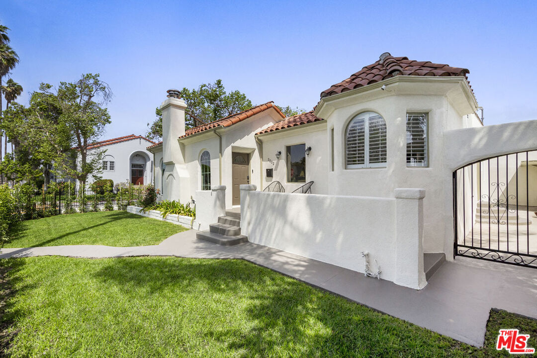 3002 Buckingham Road Los Angeles, CA 90016 - Photo 3 of 27 a front view of a house with a yard and garage