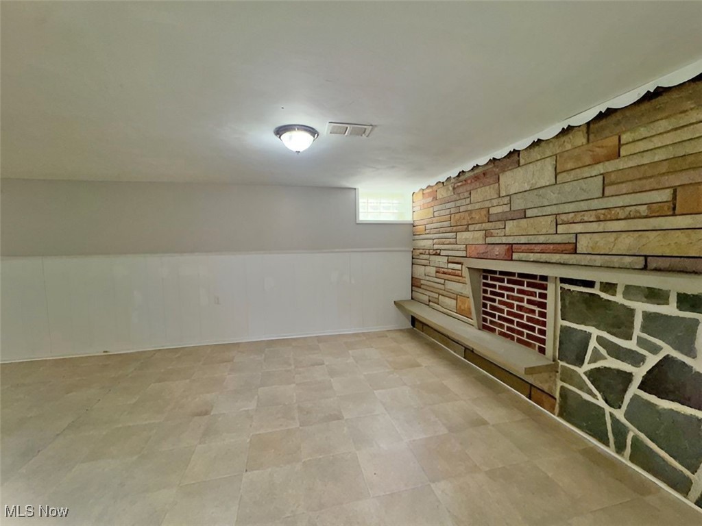 28642 Forest Road Willowick, OH 44095 - Photo 20 of 23 Below grade area with a wainscoted wall and a stone fireplace