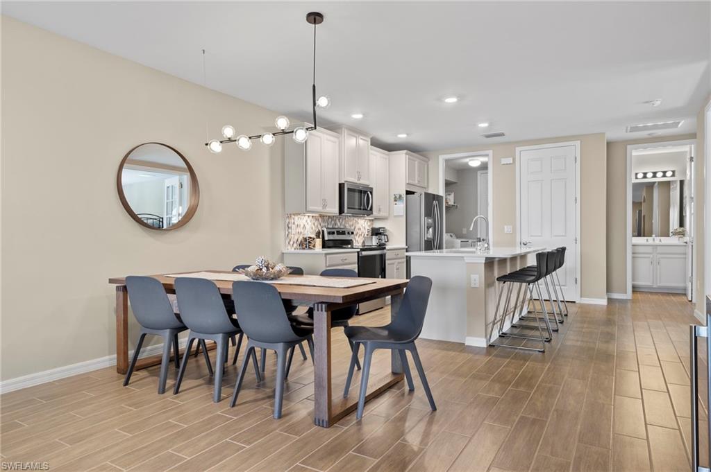 14644 Edgewater Circle Naples, FL 34114 - Photo 10 of 39 a view of a dining room with furniture and wooden floor