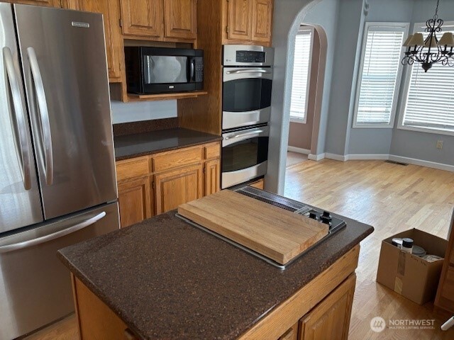 44907 West Knox Road Benton City, WA 99320 - Photo 3 of 12 a kitchen with stainless steel appliances granite countertop a refrigerator a stove and a sink with wooden floor