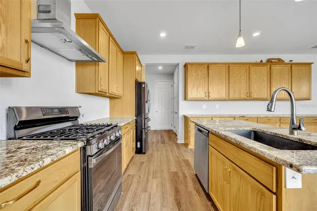 a kitchen with a sink a stove and cabinets