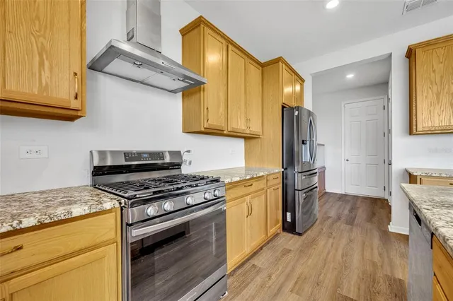 a kitchen with stainless steel appliances granite countertop a stove and a refrigerator