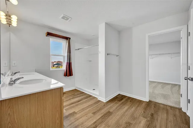 a hallway with wooden floor and chandelier
