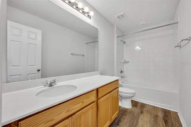 a bathroom with a sink a toilet a large mirror and shower