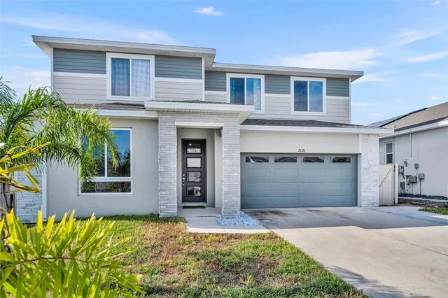 a front view of a house with a yard and garage