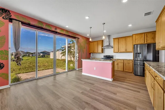 a kitchen with kitchen island granite countertop wooden cabinets and stainless steel appliances