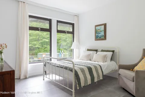 a bedroom with a bed and a large window
