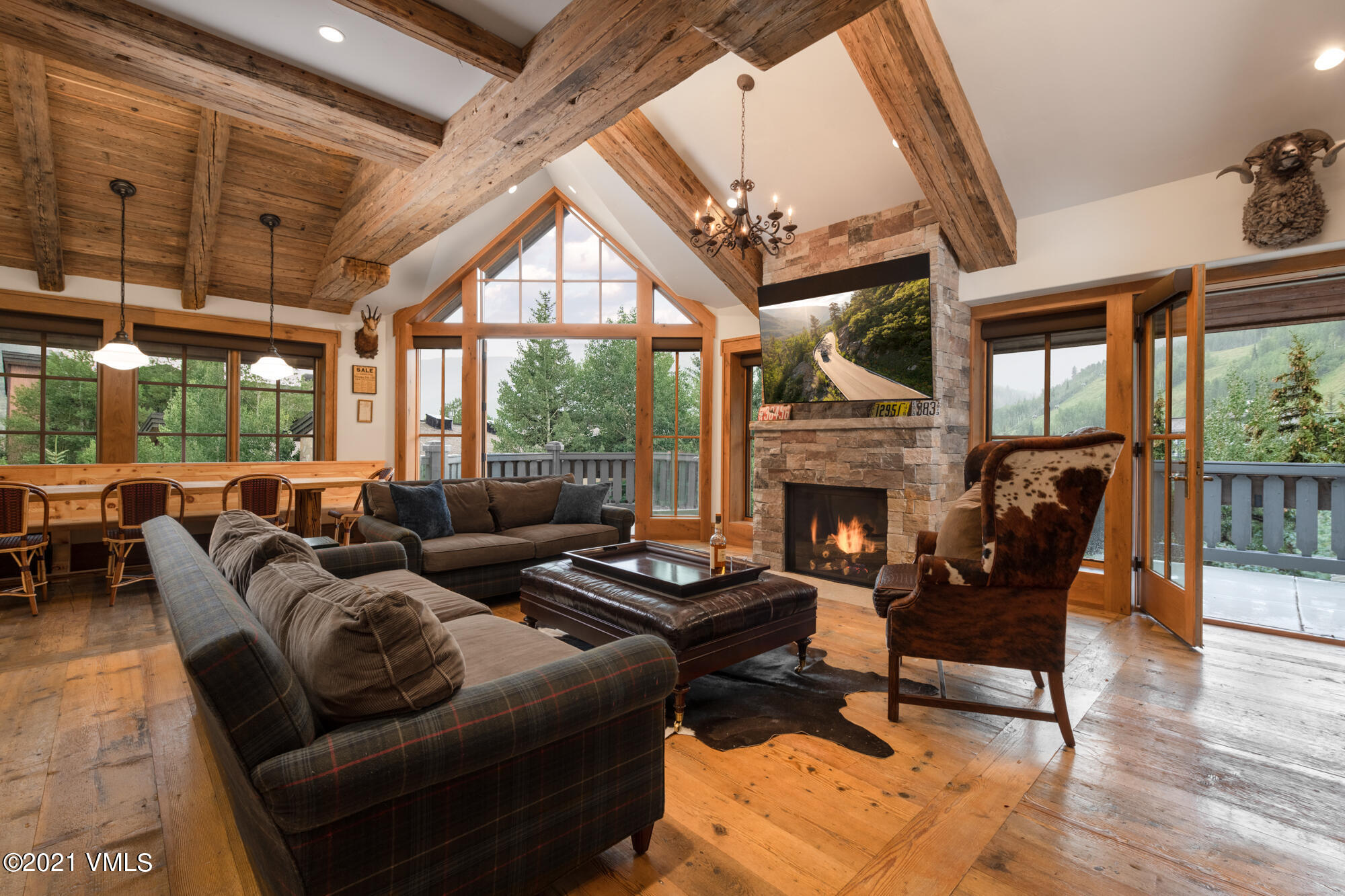 1 Willow Bridge Road, Unit 44 Vail, CO 81657 - Photo 2 of 16 a living room with furniture a fireplace and floor to ceiling windows