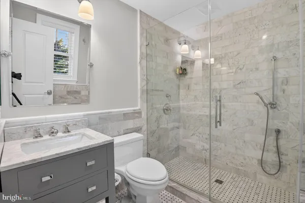 a bathroom with a sink a toilet and shower