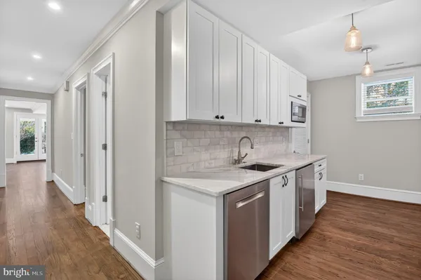 a kitchen with stainless steel appliances granite countertop a sink stove and wooden floor