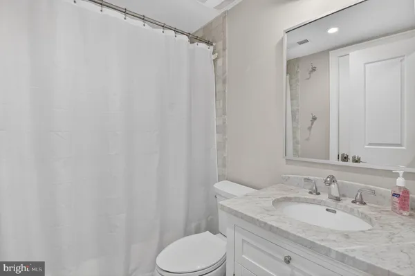 a bathroom with a granite countertop sink toilet and shower