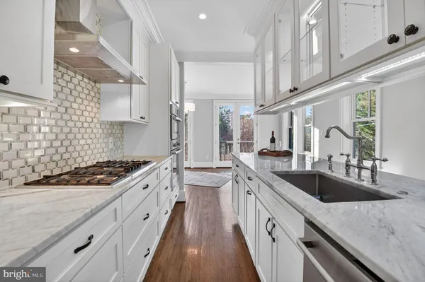 a kitchen with stainless steel appliances granite countertop a sink stove and cabinets
