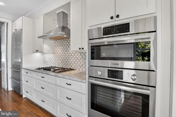 a kitchen with stainless steel appliances white cabinets and stove