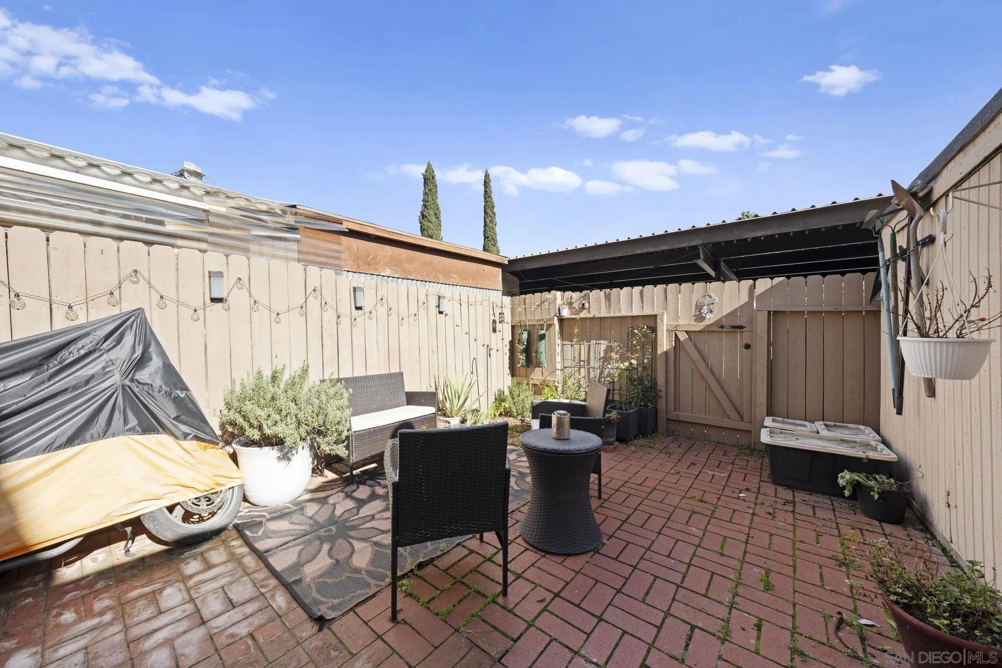 910 North Fig Street, Unit D Escondido, CA 92026 - Photo 20 of 23 a view of a patio with table and chairs potted plants with wooden fence