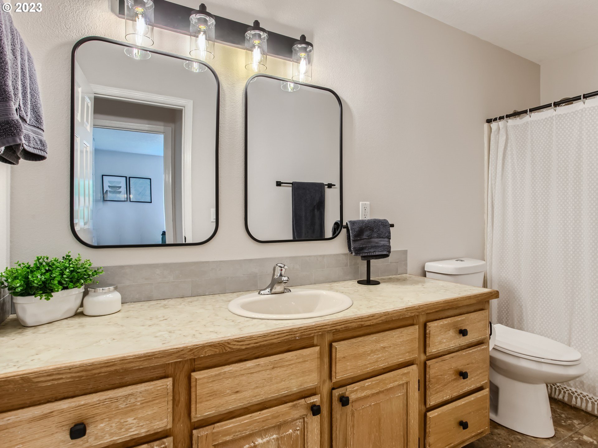 10230 Southwest Kickapoo Court Tualatin, OR 97062 - Photo 20 of 26 a bathroom with a double vanity sink and a mirror