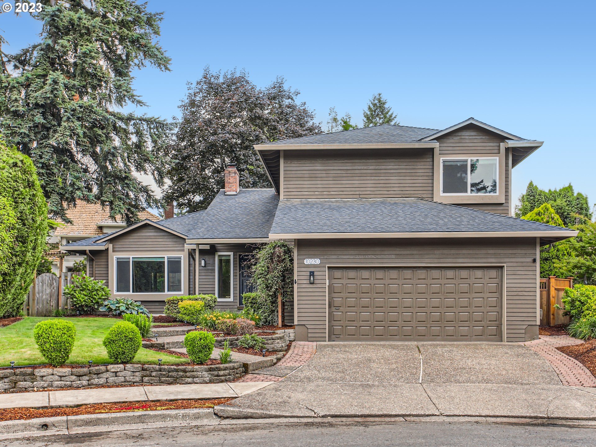10230 Southwest Kickapoo Court Tualatin, OR 97062 - Photo 2 of 26 a front view of a house with a yard and potted plants