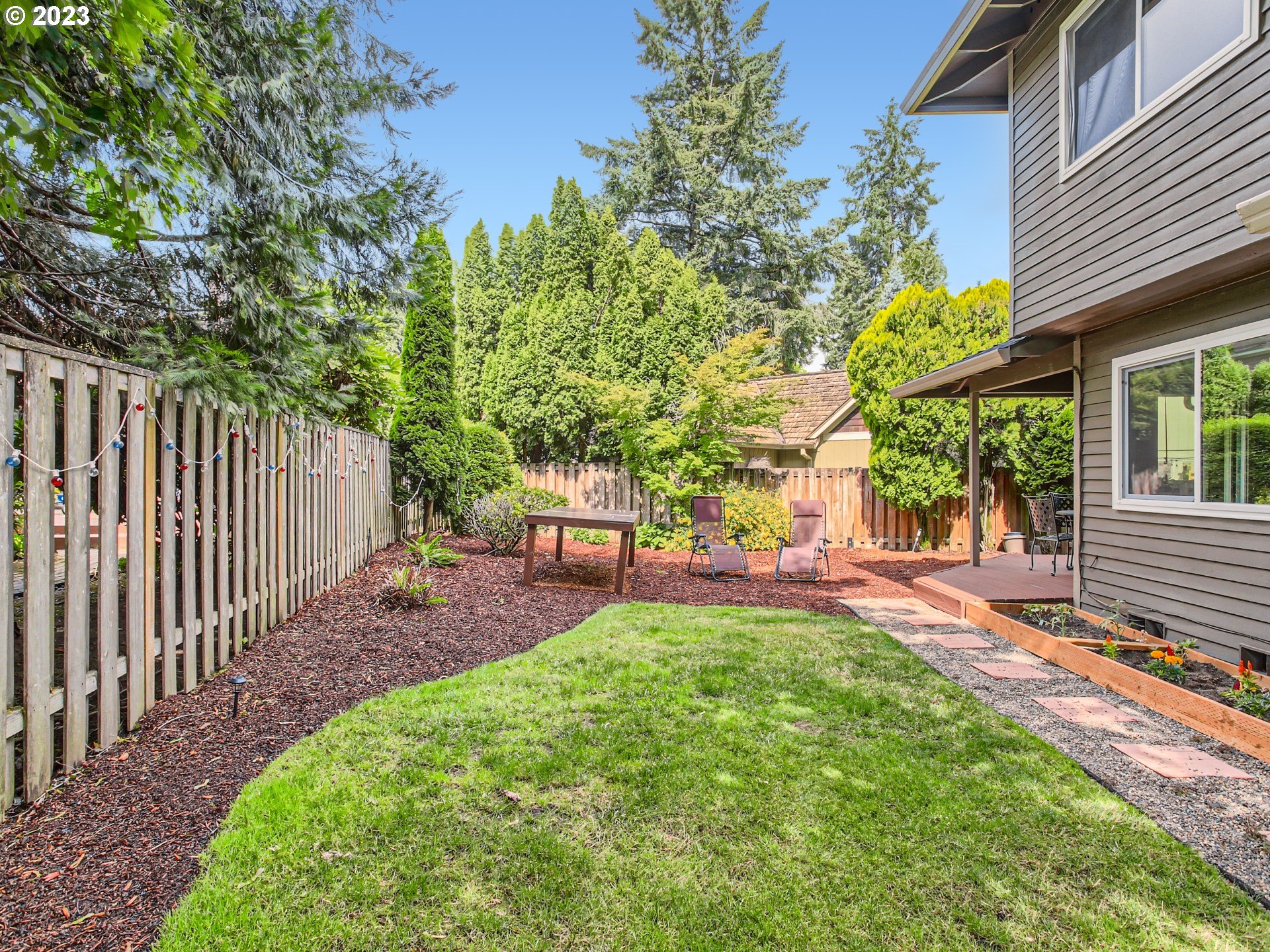 10230 Southwest Kickapoo Court Tualatin, OR 97062 - Photo 25 of 26 a view of a backyard with table and chairs and wooden fence