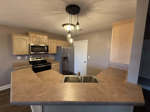 a kitchen with stainless steel appliances granite countertop a sink refrigerator and microwave