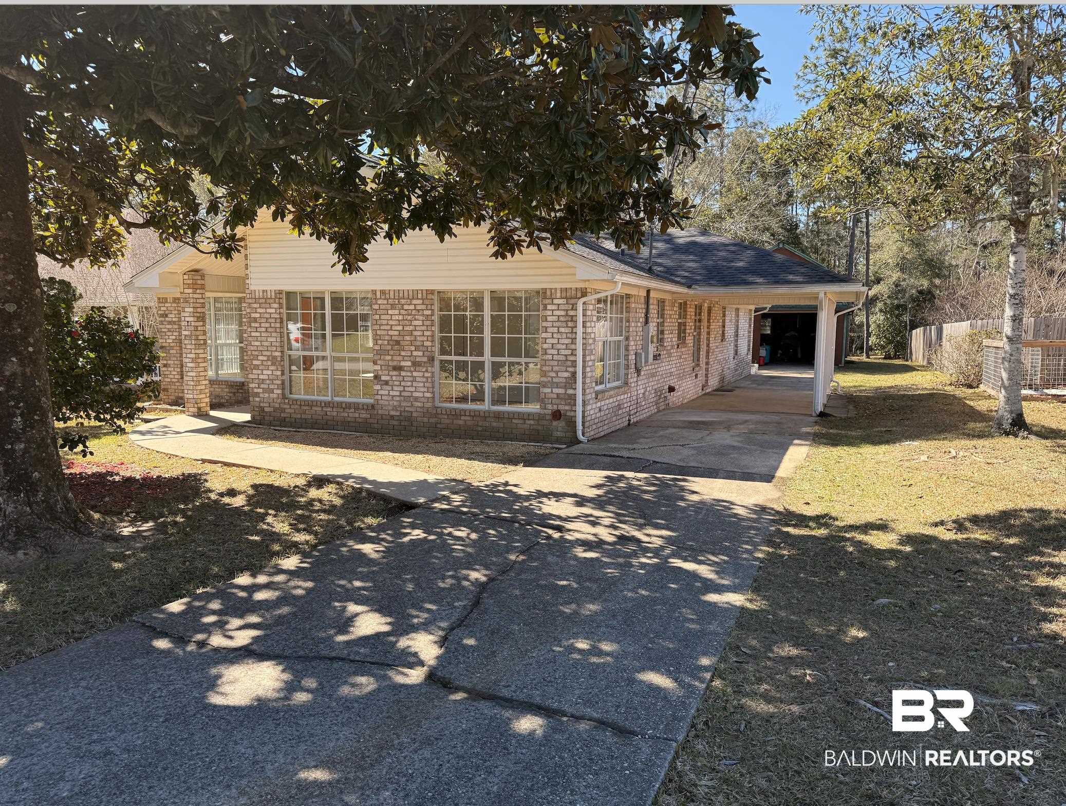 2673 Pine Ridge Drive Lillian, AL 36549 - Photo 2 of 38 View of front of home with an attached carport, brick siding, driveway, and fence