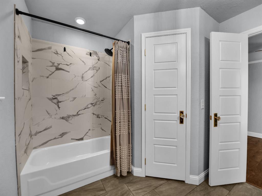 305 Gandy Street Lipan, TX 76462 - Photo 24 of 40 a bathroom with a bathtub and a shower