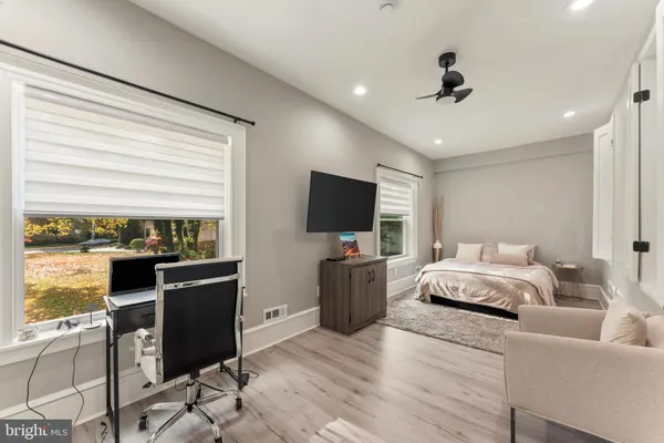 a spacious bedroom with a bed and a flat screen television
