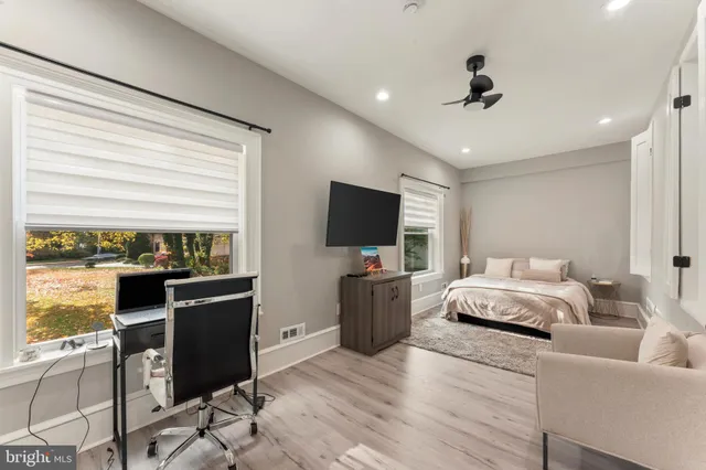 a spacious bedroom with a bed and a flat screen television