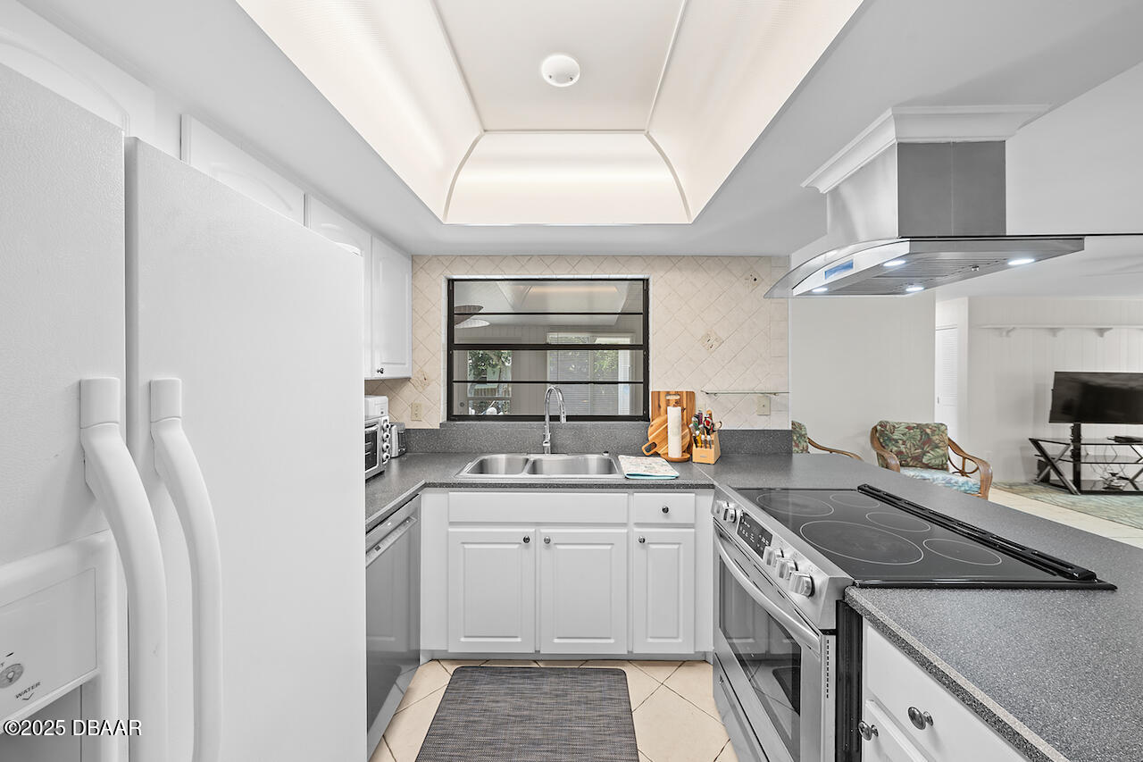 80 Cindy Lane Ponce Inlet, FL 32127 - Photo 13 of 45 a kitchen with a sink stove and cabinets
