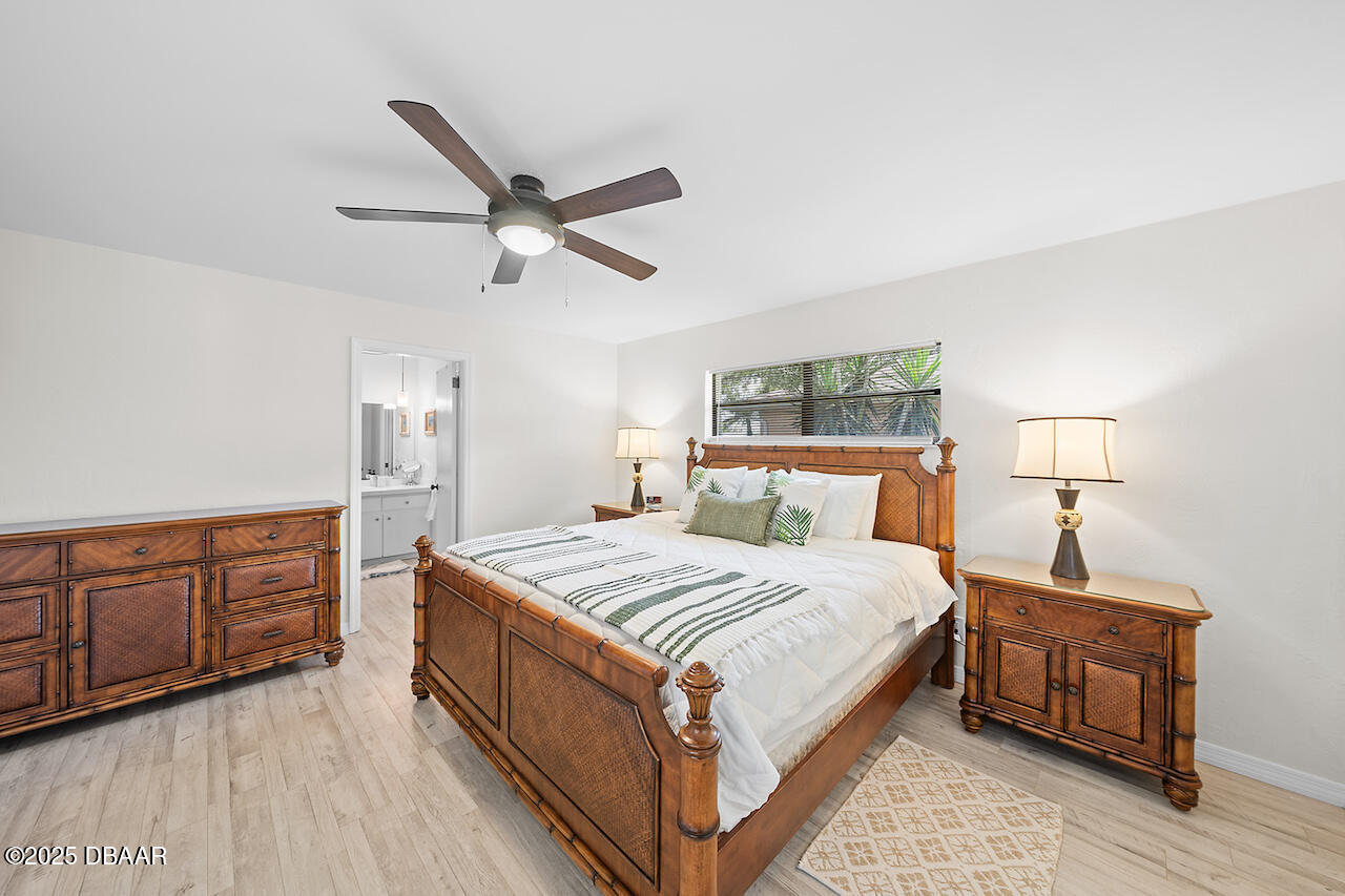 80 Cindy Lane Ponce Inlet, FL 32127 - Photo 20 of 45 a bedroom with a large bed and a chandelier