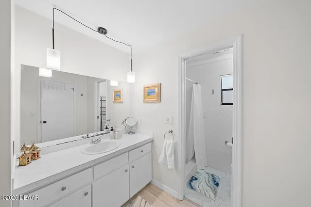 a bathroom with a double vanity sink mirror and shower
