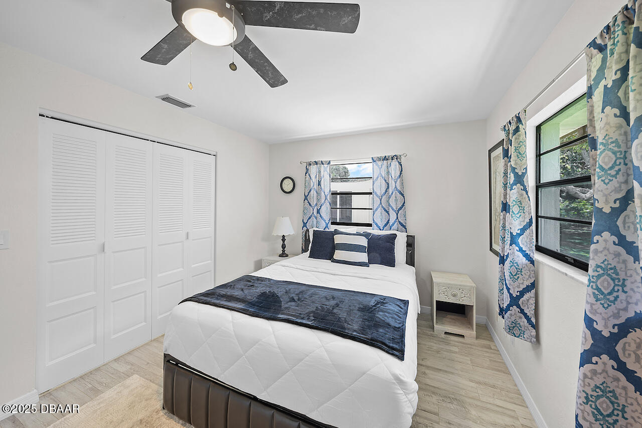 80 Cindy Lane Ponce Inlet, FL 32127 - Photo 28 of 45 a bedroom with a large bed and a chandelier