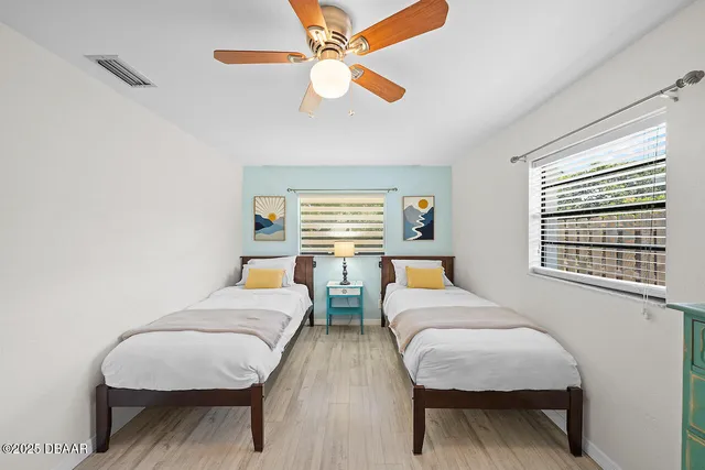 a bedroom with two beds and a chandelier