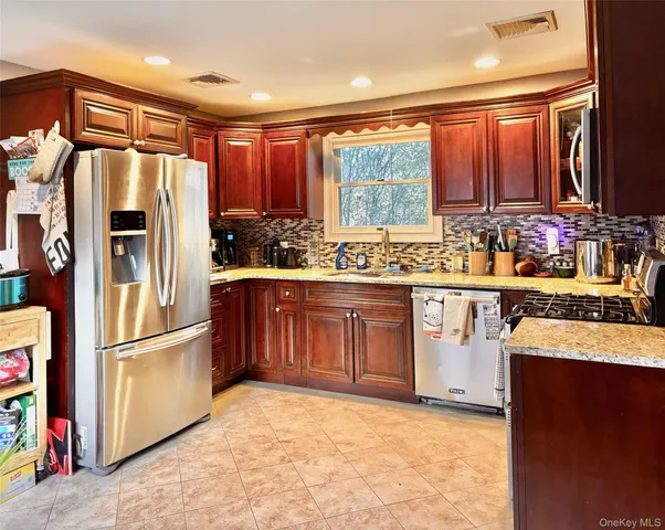 a kitchen with stainless steel appliances granite countertop a stove a sink and a microwave