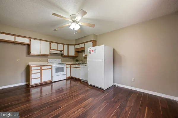 a kitchen with a refrigerator and white cabinets