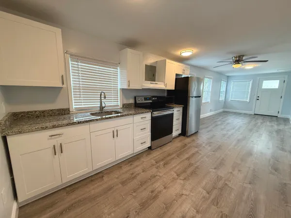 a kitchen with stainless steel appliances granite countertop a stove a sink and a microwave