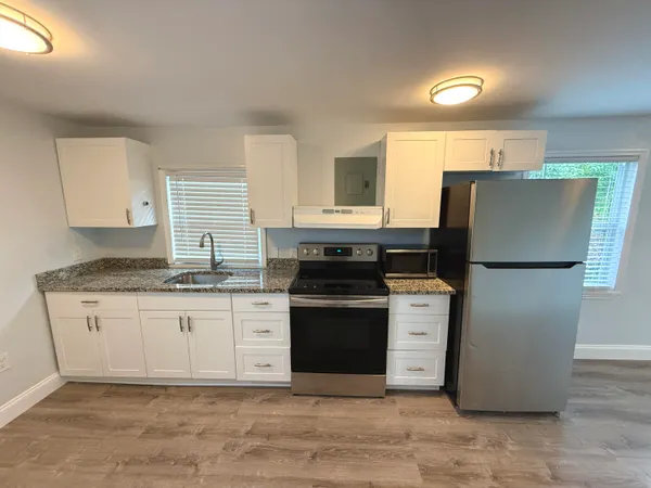 a kitchen with stainless steel appliances granite countertop a stove a sink and a refrigerator