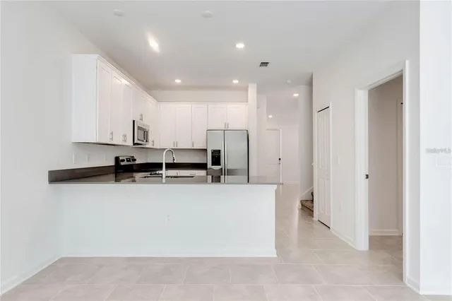 a large kitchen with stainless steel appliances a refrigerator a oven and a sink