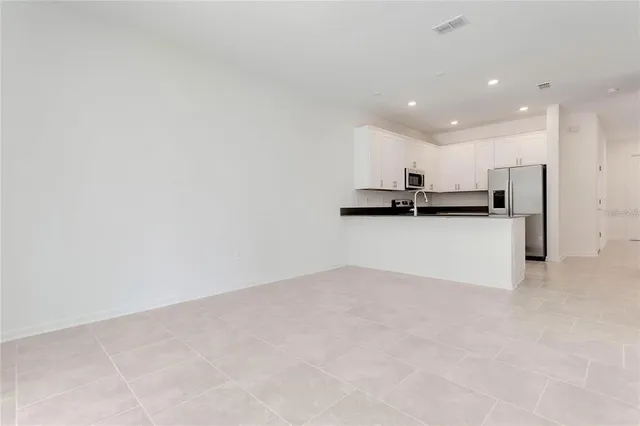 a view of a kitchen with a sink wooden cabinets and stainless steel appliances