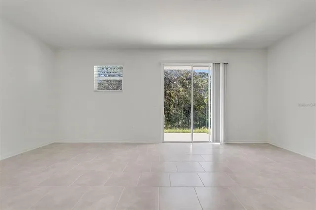 an empty room with floor to ceiling window and an outdoor view