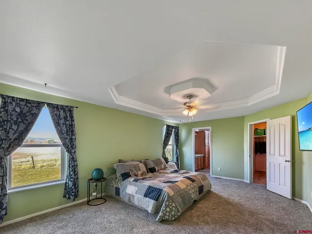 a spacious bedroom with a bed and a chandelier