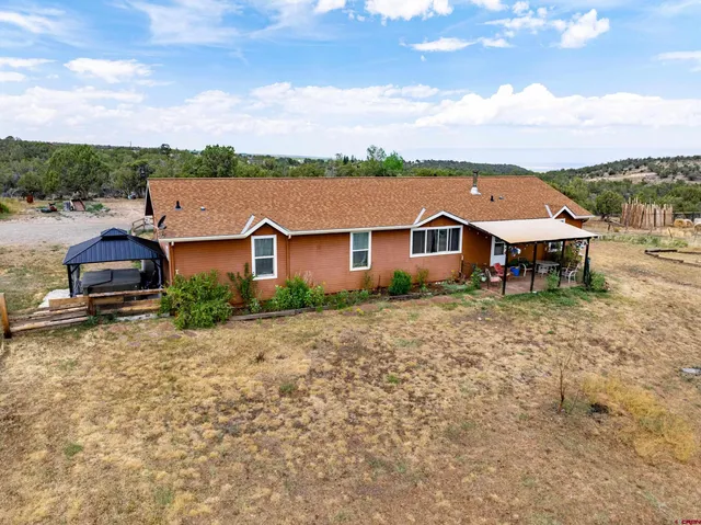 a aerial view of a house with a yard table and chairs