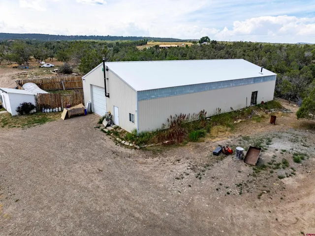 an aerial view of a house with a yard and lake view