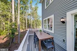 a view of a patio with table and chairs with wooden floor and fence