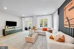 a living room with furniture a flat screen tv and a large window